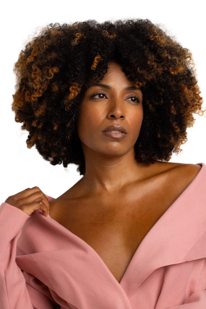 Portrait background removal example: woman with curly hair in a pink blazer as a transparent cutout
