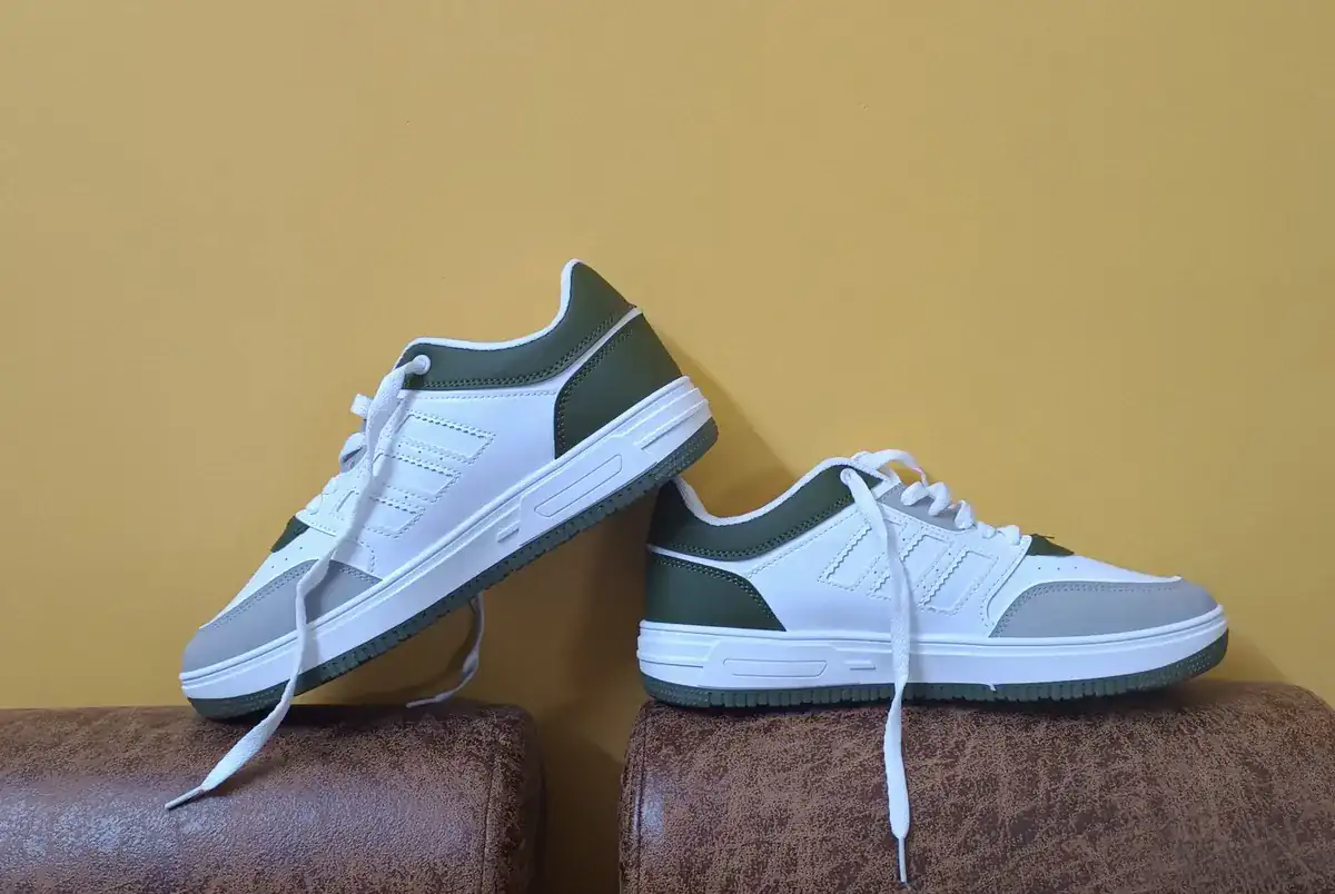 Original product photo of white and green sneakers against a yellow wall